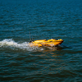 CHCNAV Apache 6 unmanned surface vessel surveying coastal riverbed in deep water available to buy or hire from Tri-Site.